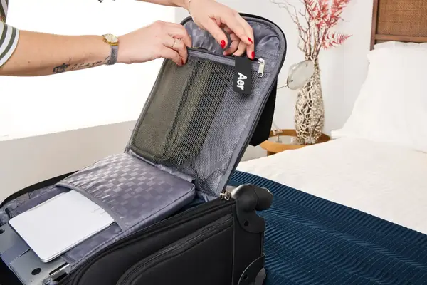 A person unzips a mesh pocket on the inside of the Samsonite Theorym Underseater