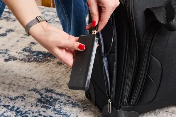 A person plugs their phone into a USB cable in the Samsonite Theorym Underseater