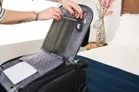 A person unzips a mesh pocket on the inside of the Samsonite Theorym Underseater