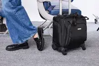 A person wheels the Samsonite Theorym Underseater over gray carpet