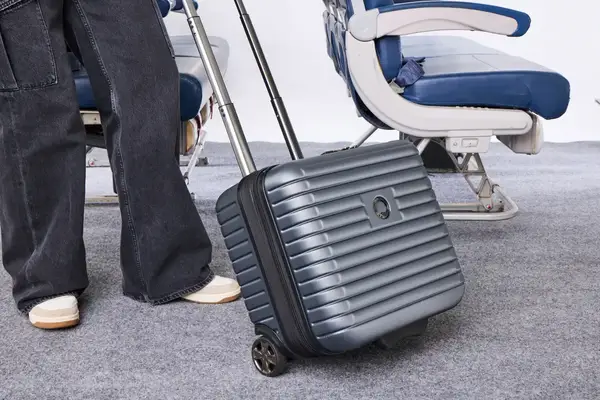 A person wheels the Delsey Paris Cruise 3.0 2-Wheeled Underseater over carpet