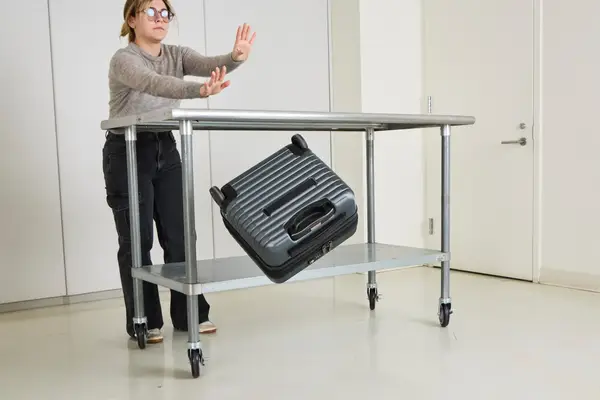 A person throws the Delsey Paris Cruise 3.0 2-Wheeled Underseater off of a metal table