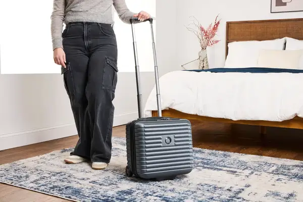 A person wheels the Delsey Paris Cruise 3.0 2-Wheeled Underseater over a carpet