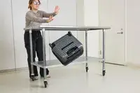 A person throws the Delsey Paris Cruise 3.0 2-Wheeled Underseater off of a metal table