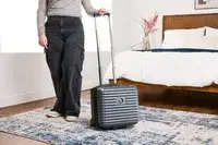 A person wheels the Delsey Paris Cruise 3.0 2-Wheeled Underseater over a carpet