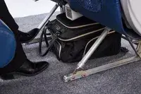 The Kenneth Cole Reaction Chelsea Luggage Expandable Underseater Spinner under an airplane seat