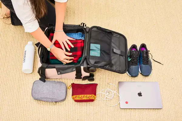 A person packing the Calpak Luka Soft-sided Mini Carry-on Luggage