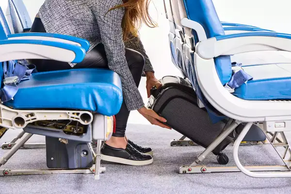 A person places the Hartmann Herringbone Deluxe Underseater under the seat in front of them