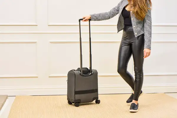 A person wheels the Hartmann Herringbone Deluxe Underseater over a rug