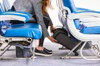 A person places the Hartmann Herringbone Deluxe Underseater under the seat in front of them