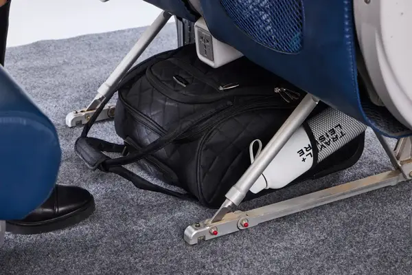The Rockland Melrose Upright Wheeled Underseater Luggage under an airplane seat