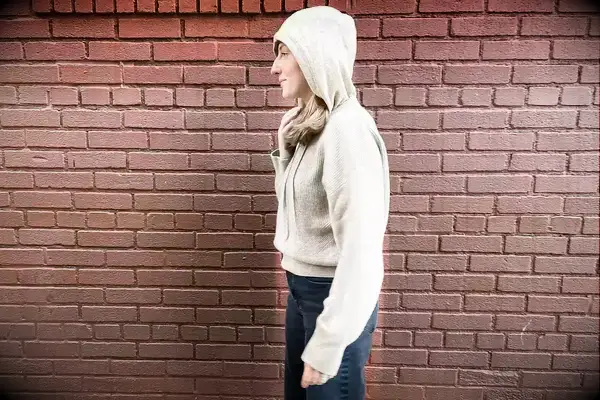 A woman wearing the Lilysilk Eshe 2-in-1 Cashmere Detachable Hoodie with the hood up