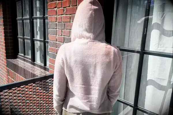 A person turned around wearing the Naadam Signature Cashmere Cropped Zip-up Hoodie