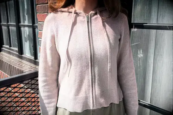 A person wearing the Naadam Signature Cashmere Cropped Zip-up Hoodie