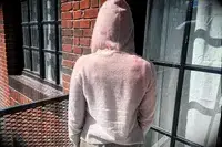 A person turned around wearing the Naadam Signature Cashmere Cropped Zip-up Hoodie