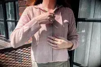 A person wearing the Naadam Signature Cashmere Cropped Zip-up Hoodie