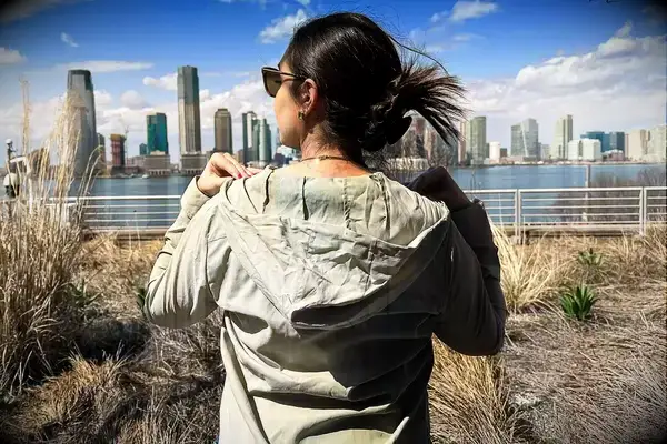 the back of a woman wearing the Hikerkind Trail Sun Hoodie 01