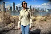 The front of a woman wearing the Hikerkind Trail Sun Hoodie 01