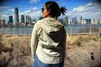 The back of a woman wearing the Hikerkind Trail Sun Hoodie 01