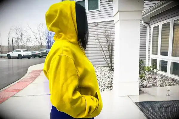 Side view of a woman wearing a Nike Sportswear Club Fleece Pullover Hoodie with the hood up