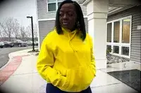 Woman stands outside wearing a Nike Sportswear Club Fleece Pullover Hoodie