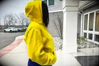 Side view of a woman wearing a Nike Sportswear Club Fleece Pullover Hoodie with the hood up