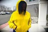 Woman looks down while wearing a Nike Sportswear Club Fleece Pullover Hoodie