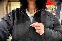 A person pulling the zipper on the Athleta Easy Fleece Half Zip Hoodie