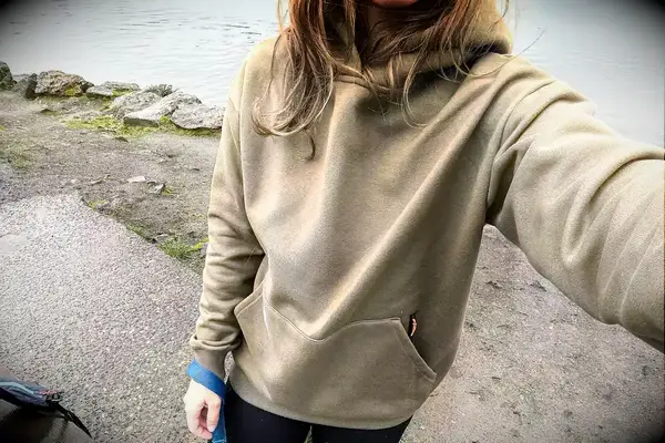 A person standing next to a body of water wearing the Portland Gear Cloudburst Hoodie