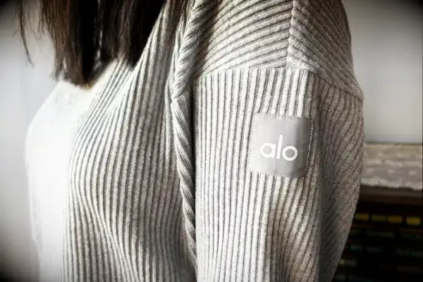 A close up of a person wearing the Alo Muse Hoodie
