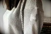 A close up of a person wearing the Alo Muse Hoodie