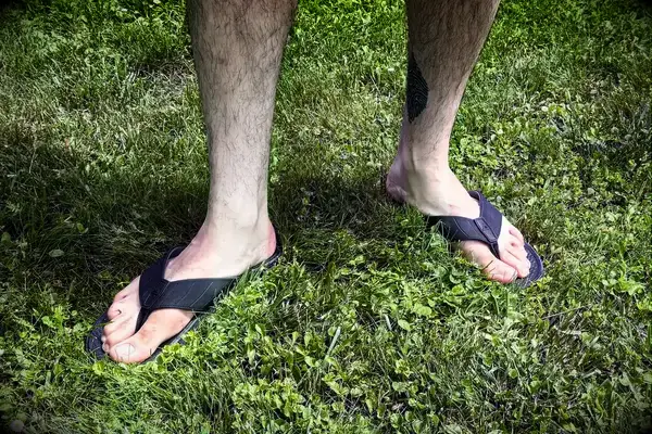 A person wears the Reef The Deckhand sandals in grass
