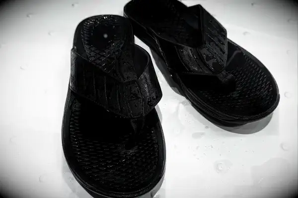 An overhead view of a pair of Reef The Deckhand sandals in a shower