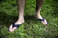 A person wears the Reef The Deckhand sandals in grass