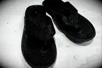 An overhead view of a pair of Reef The Deckhand sandals in a shower