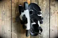 Quoc x Restrap Sandal with straps displayed on a wooden surface