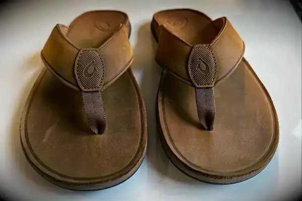 Olukai Tuahine Flip Flop displayed on white desk