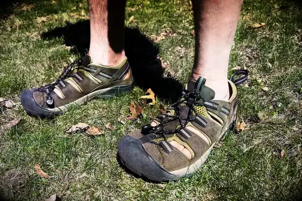 A man stands on grass wearing KEEN Men’s Hyperport H2 Sandal