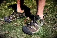 A man stands on grass wearing KEEN Men’s Hyperport H2 Sandal