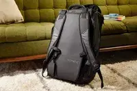 Hands putting a laptop into the Matein Travel Backpack 40L