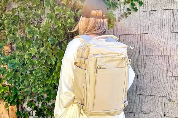 Photo of person wearing a cream-colored backpack
