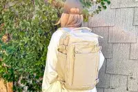 Photo of person wearing a cream-colored backpack