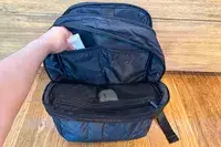 Photo of arm pulling item out of the calpak luka backpack