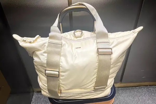 Caraa Sport Tote filled sitting on a suitcase