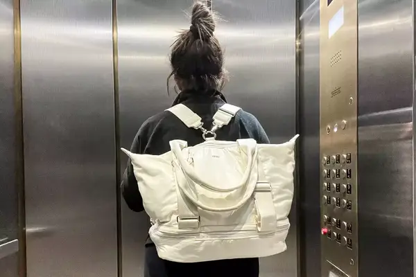 Back view of a person wearing the Caraa Sport Tote in an elevator