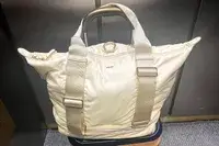 Caraa Sport Tote filled sitting on a suitcase