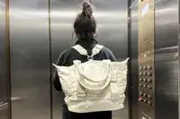 Back view of a person wearing the Caraa Sport Tote in an elevator