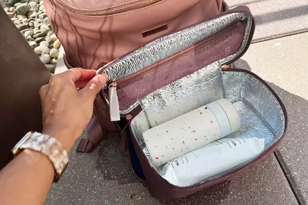 Hand opening the lid of the MinkeeBlue Nichet Backpack 3.0