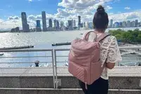 Person wearing the MinkeeBlue Nichet Backpack 3.0 looking across water at a city skyline