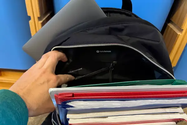 Hand opening an interior pocket in the lululemon City Adventurer Backpack